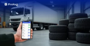Uma borracharia com vários pneus e um caminhão parado. Na frente, uma pessoa utilizando as funcionalidades de controle de pneus do Prolog.
