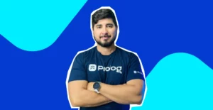 Foto do Tiago Damazio de braços cruzados. Atrás, fundo azul com turquesa.