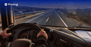 homem branco com mão no volante dirige um caminhão de olho no painel no controle do km.